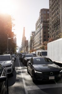 Pendler mit Hybrid Auto vor Büro